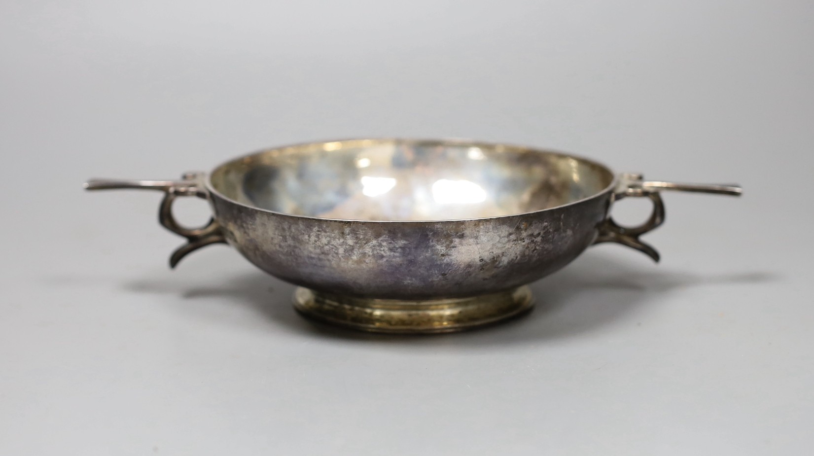 A George V silver porringer, with planished decoration, London 1910, 22cm, 247 grams and eight Reed and Barton table knives with plated handles